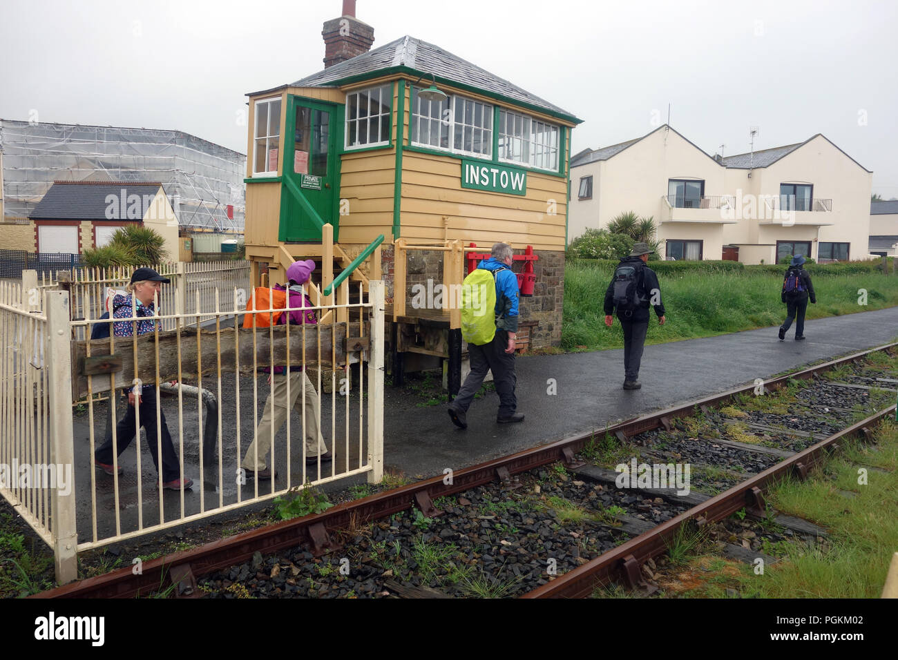 A Walking Group Passing the Disused Railway Single Box at Instow in the Rain on the South West Coastal Path, Devon, England, UK. Stock Photo