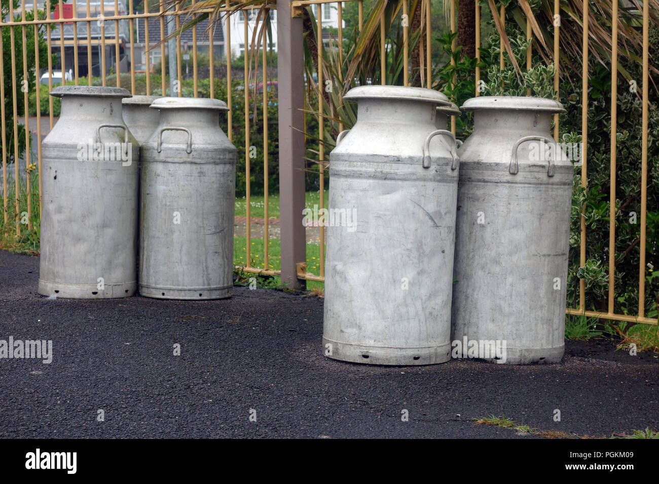 Six Old Fashion Milk Churns on the Platform of the Disused Railway Station at Instow on the South West Coastal Path, Devon, England, UK. Dozen Stock Photo