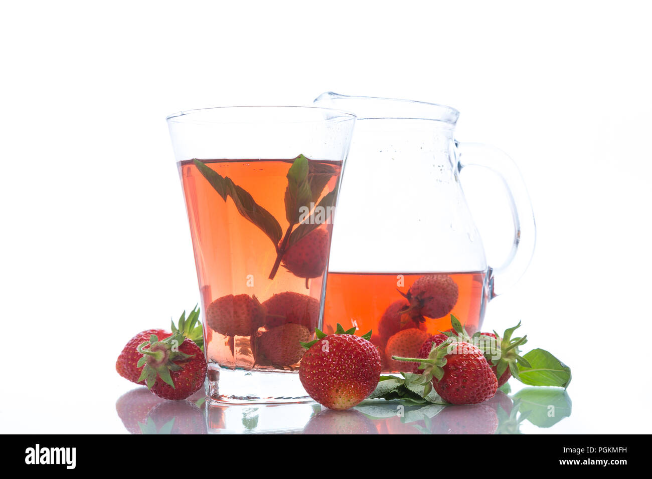 Sweet compote of ripe red strawberries in a glass decanter on a white background Stock Photo