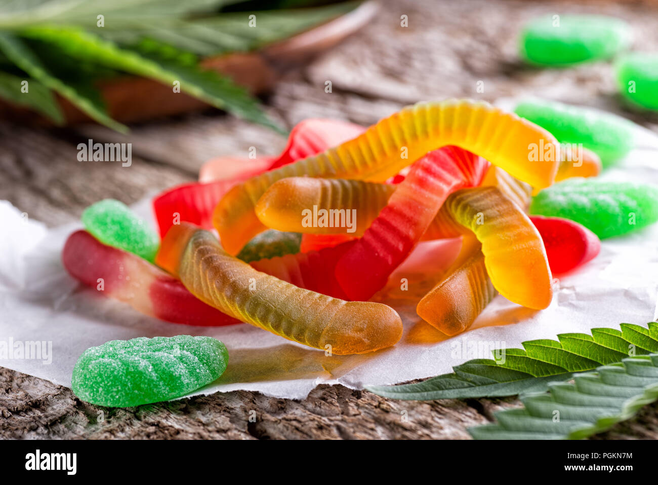 Cannabis infused gummy candy on a rustic table top with marijuana