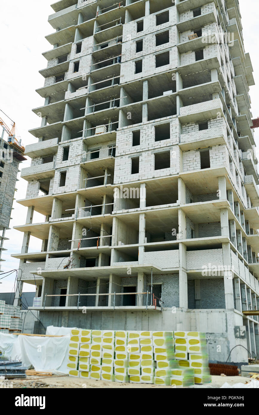 Low angle view at unfinished apartment building on construction site, copy space background Stock Photo