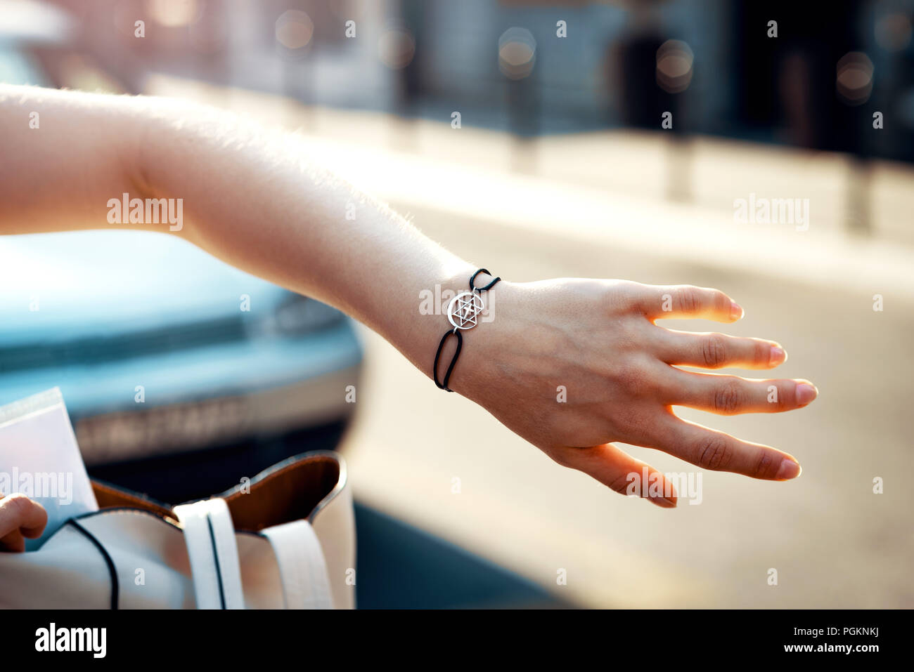 Woman wearing multi religions symbol on her arm bracelet. Toned image. Stock Photo