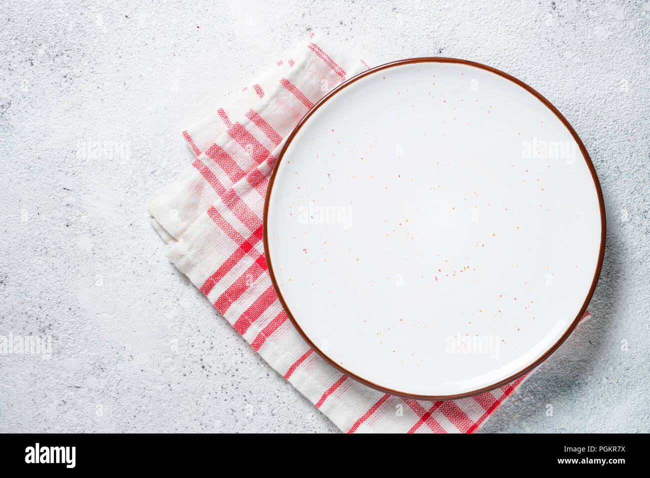 White plate and napkin on stone table top view. Stock Photo