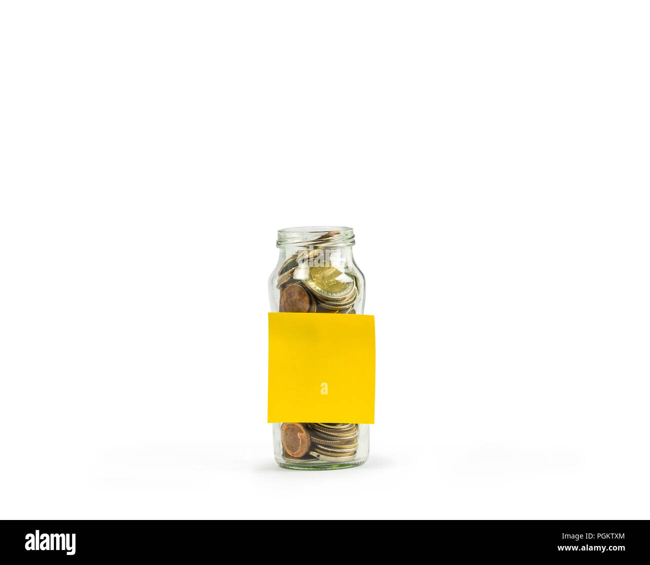 Savings, Investment growing money concept : A full coins in a clear glass jar with a empty yellow post paper on white background include clipping path Stock Photo