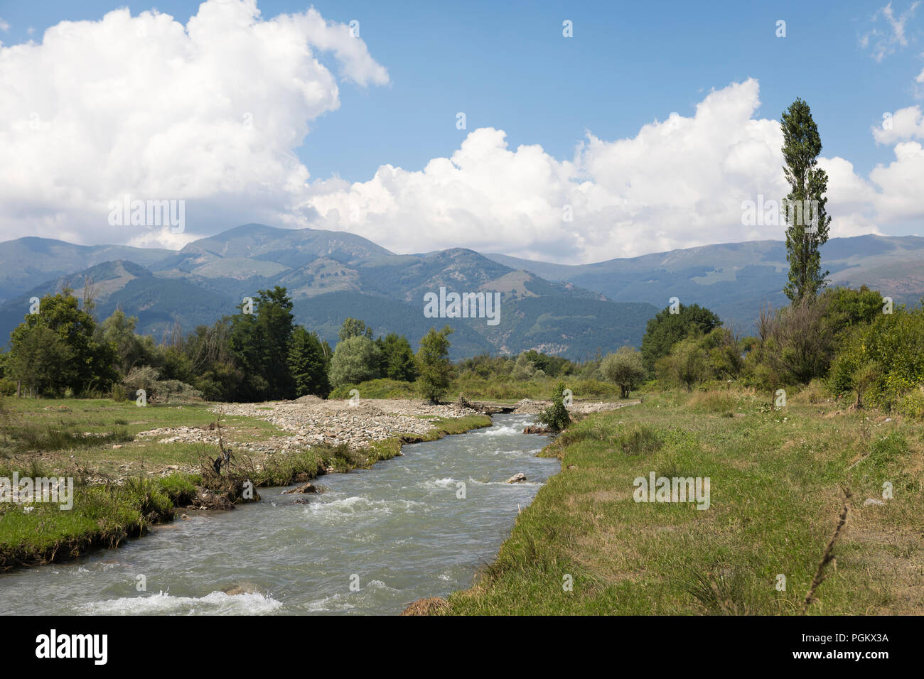 River streaming through beautiful landscape with Balkan mountains in background, nature in Bulgaria Stock Photo
