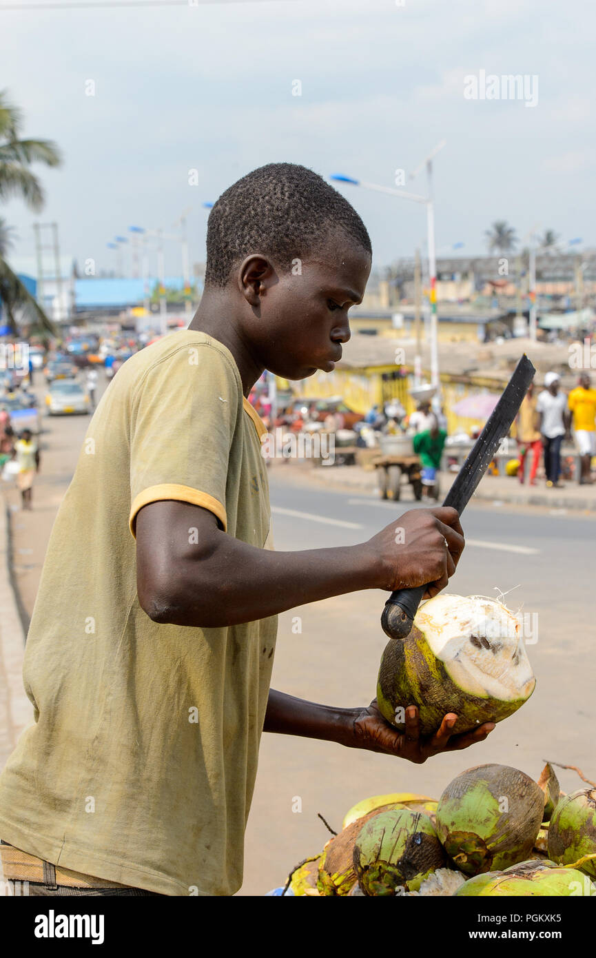 ELMINA, GHANA JAN 18, 2017 Unidentified Ghanaian boy chops coconuts