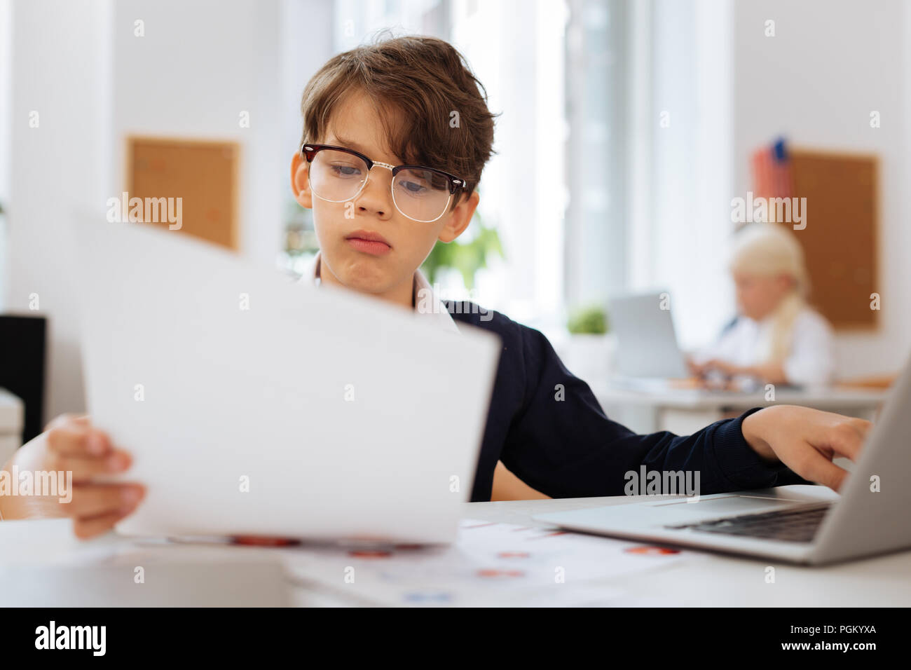 Thoughtful boy checking a document on a laptop Stock Photo - Alamy