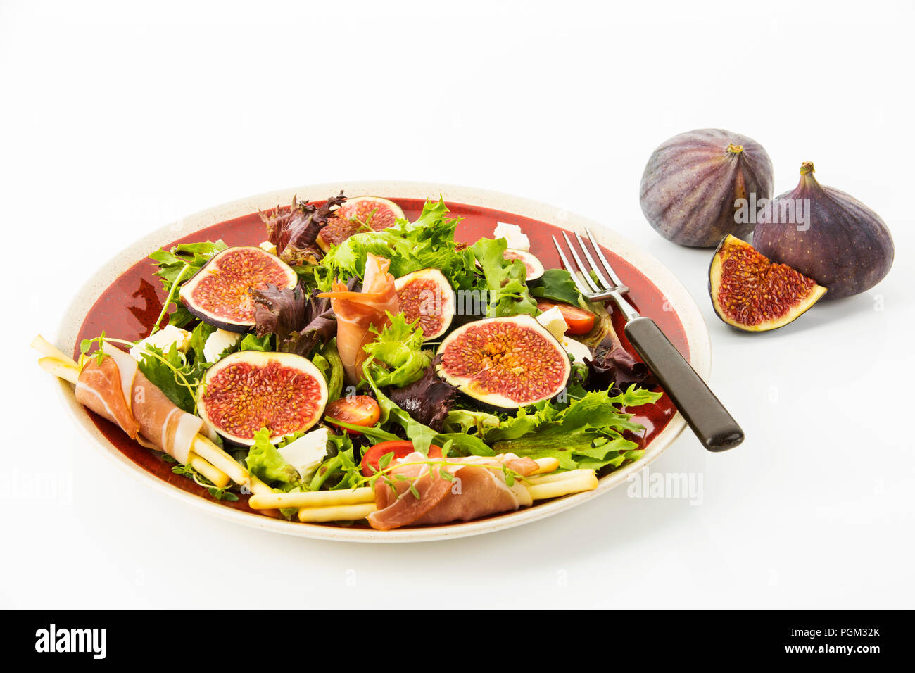 gemischter Blattsalat mit Feigen, Tomaten, Schafskaese und Crossinis mit Schinken, Freisteller Stock Photo