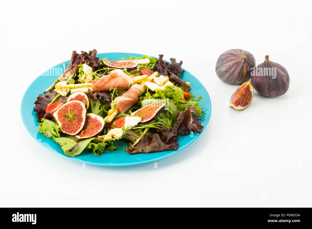 gemischter Blattsalat mit Feigen, Tomaten, Schafskaese und Crossinis mit Schinken, Freisteller Stock Photo