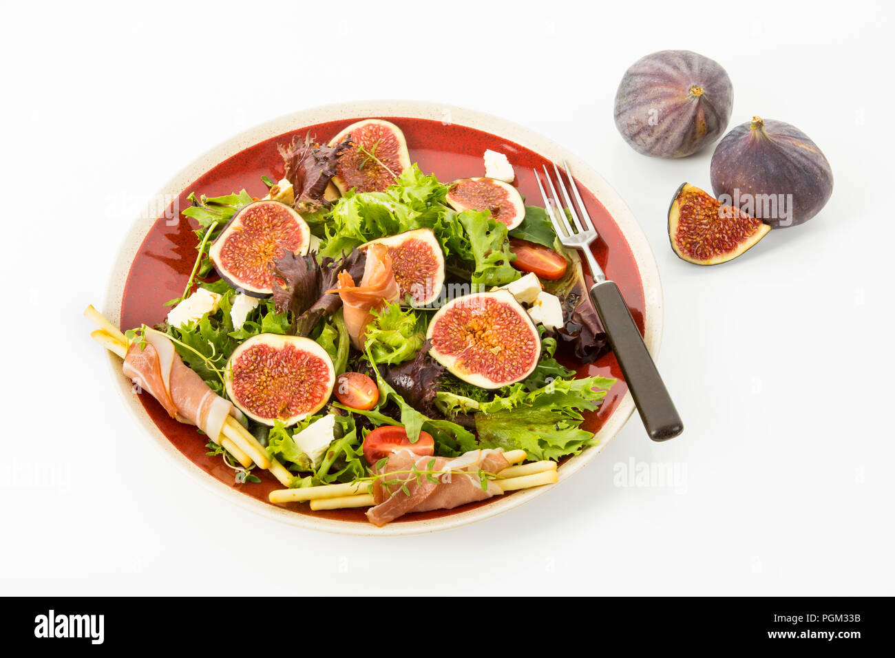 gemischter Blattsalat mit Feigen, Tomaten, Schafskaese und Crossinis mit Schinken, Freisteller Stock Photo