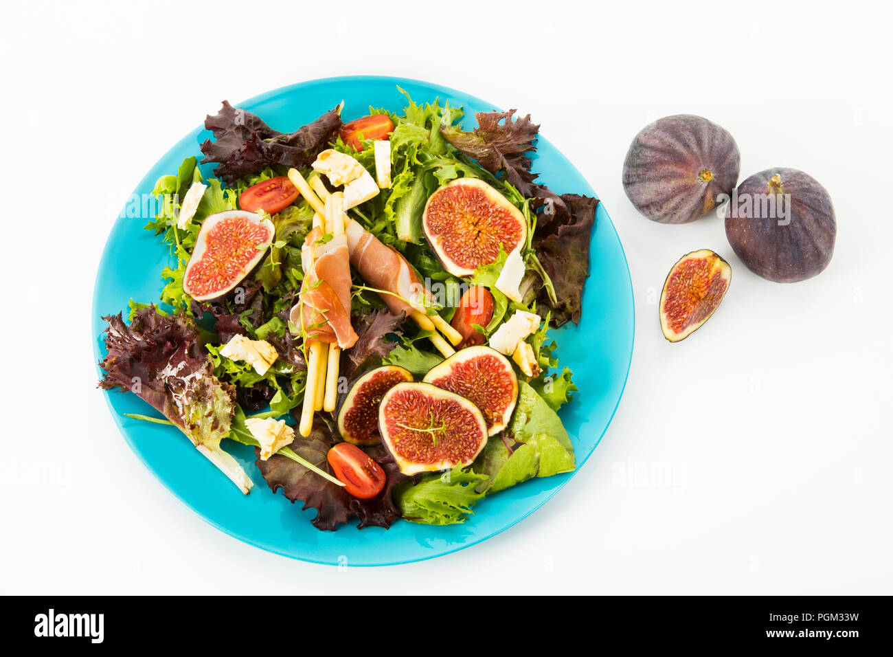gemischter Blattsalat mit Feigen, Tomaten, Schafskaese und Crossinis mit Schinken, Freisteller Stock Photo