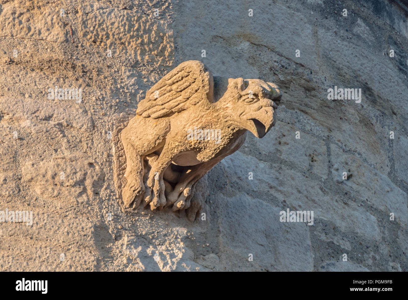 middle age bird gargoyle on a top of an ancient castle tower Stock Photo