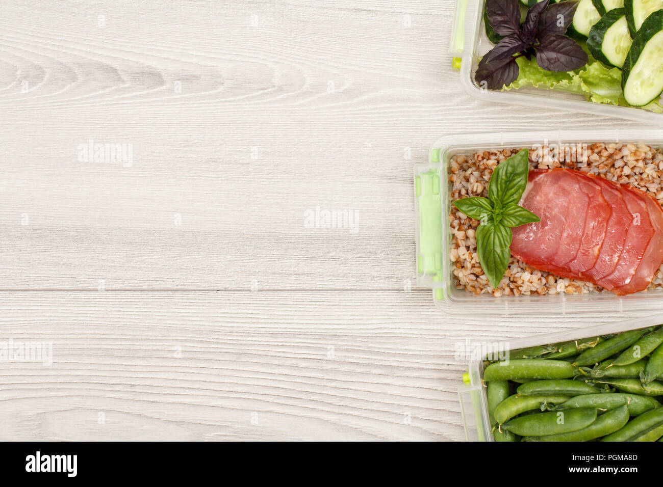 Plastic meal prep containers with fresh green peas, boiled buckwheat