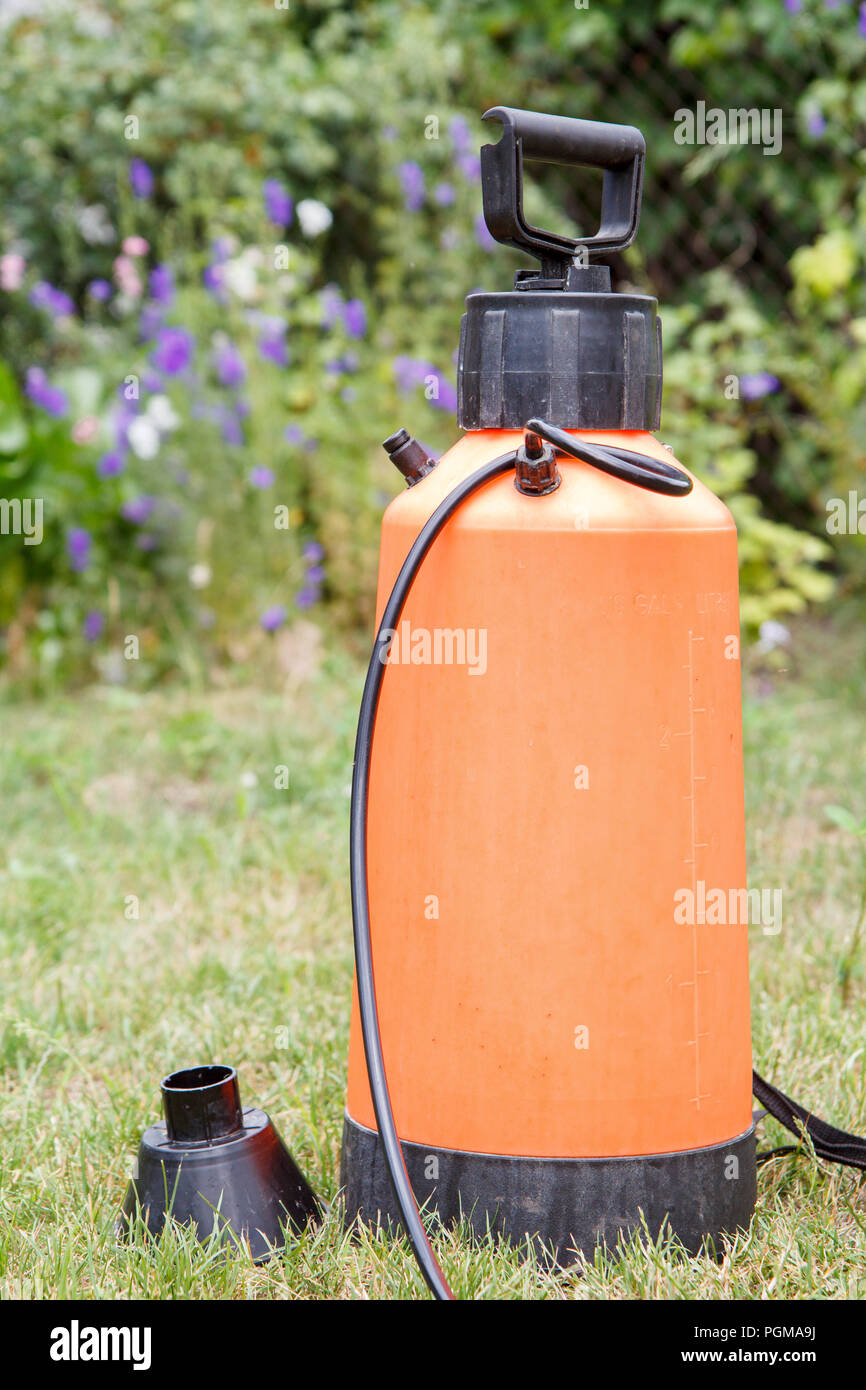 Fertilizer pesticide garden sprayer on lawn with green grass and