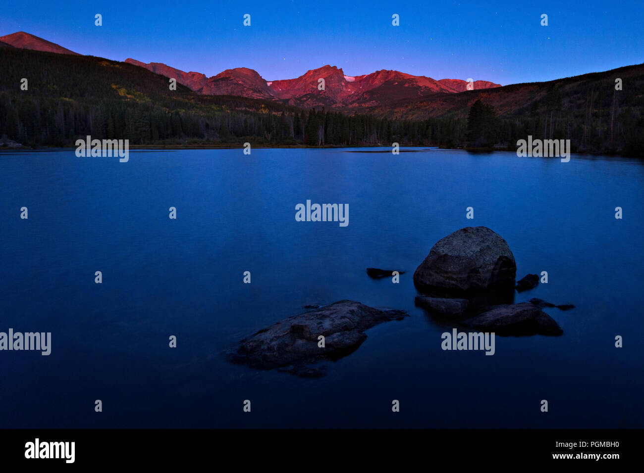 Sunlit peaks of the Rocky Mountains at sunrise at Sprague Lake, Rocky Mountain National Park, Colorado, USA Stock Photo