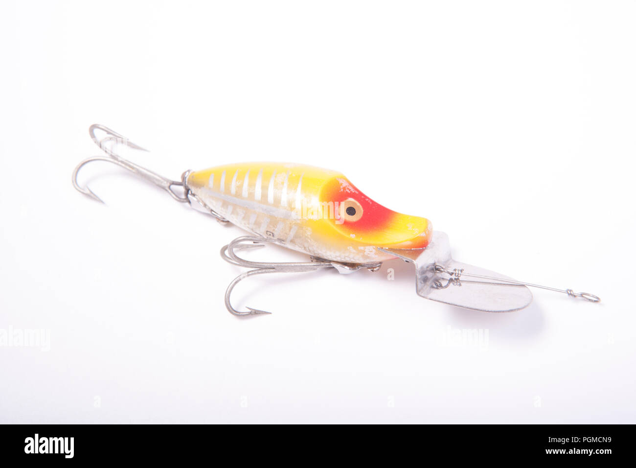 A small fishing lure, or plug, equipped with two treble hooks for catching predatory fish. This plug is designed to dive when it is reeled in.  From a Stock Photo