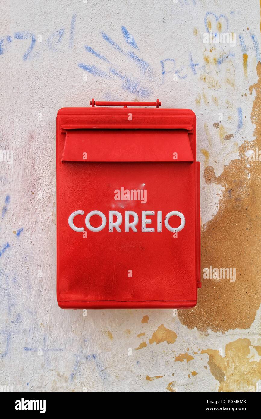 Colorful metallic mail box in red color on wall with old paint in