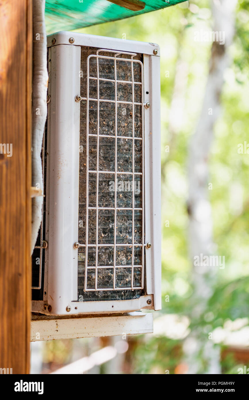 Closeup outdoor air condition unit with clogged obstructed compressor radiator grill. Details