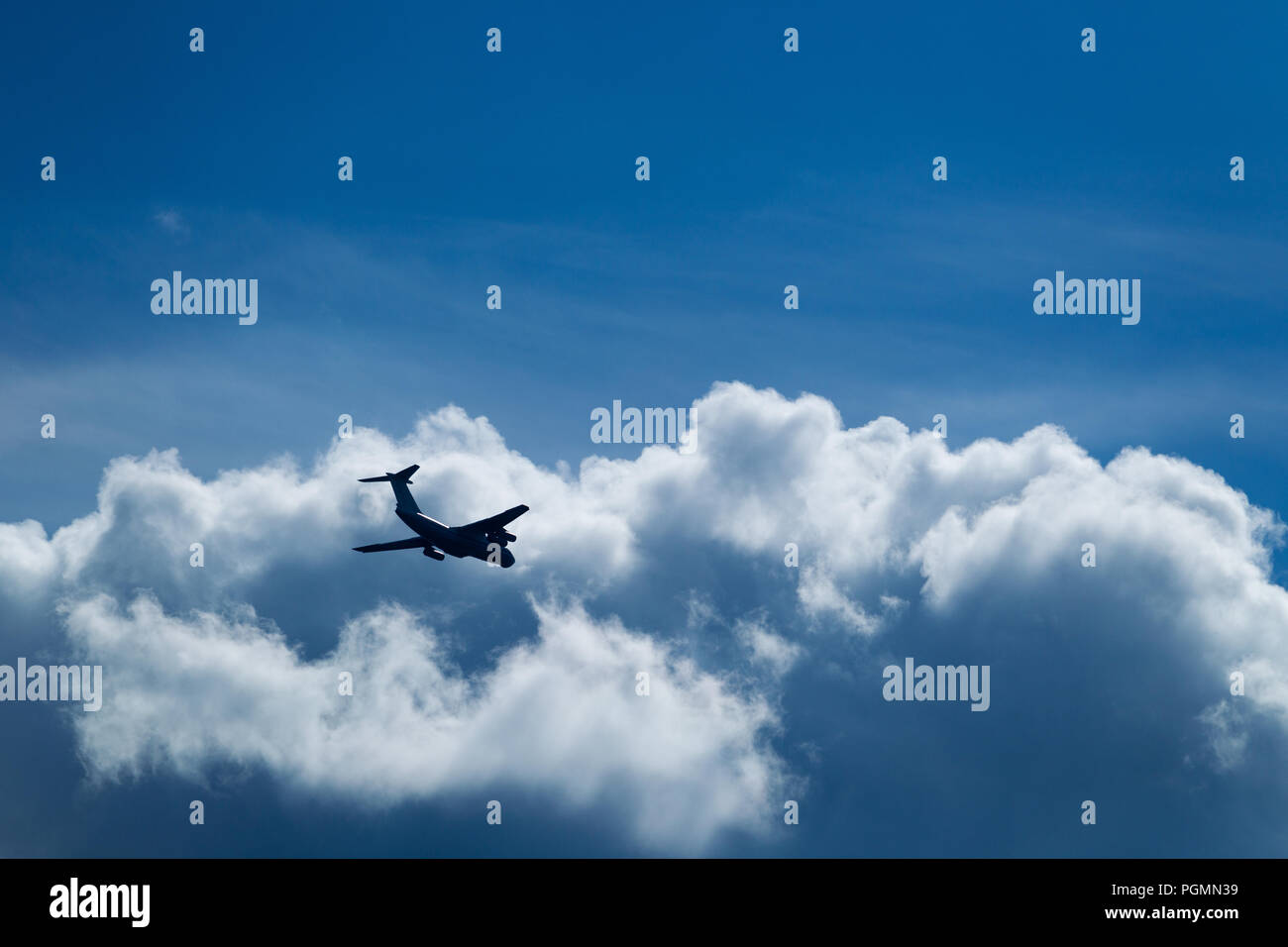 Transport plane flies against the background of a summer blue sky with ...