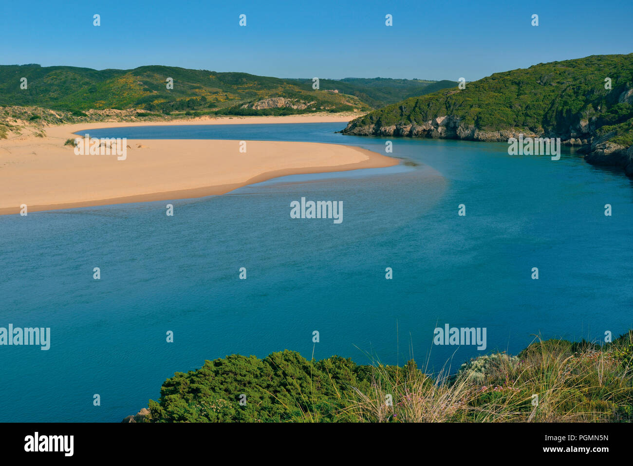 Beautiful river with turquoise water surrounded by sand banks and green hills Stock Photo
