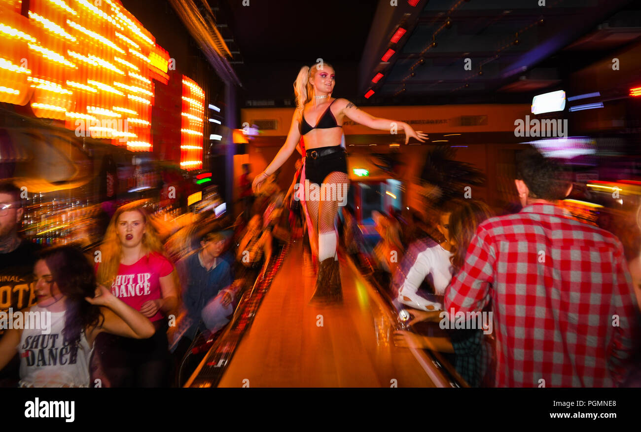 Inside a Coyote Ugly bar, where women dance on the bar as people order drinks, inspired by the hit film of the same name. Stock Photo
