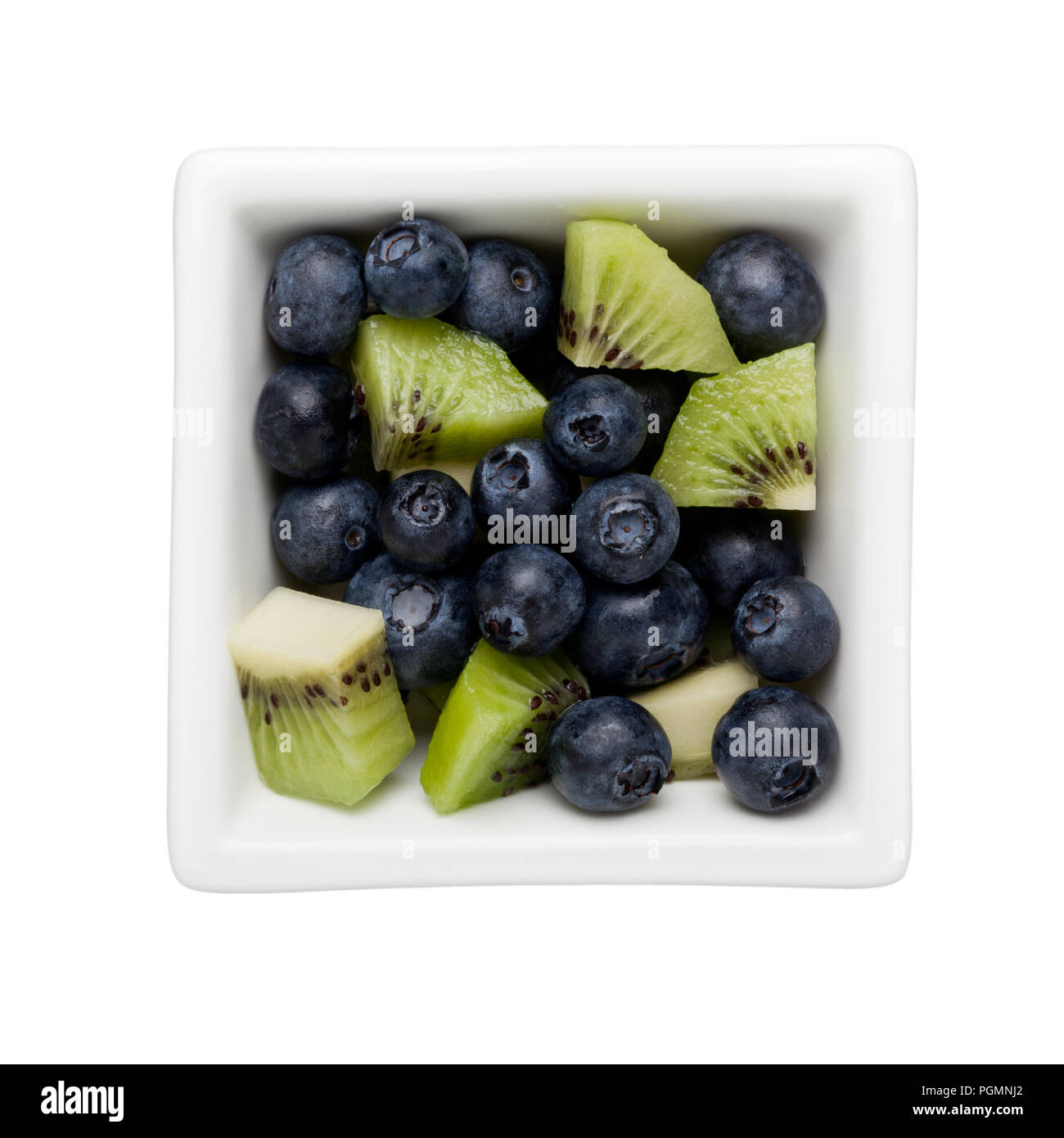 Blueberries and diced kiwifruit in a square bowl isolated on white background Stock Photo