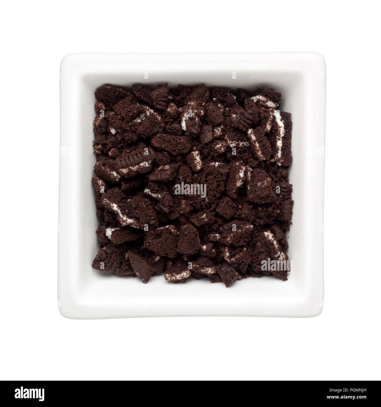 Crumbled oreo biscuit in a square bowl isolated on white background; Stock Photo
