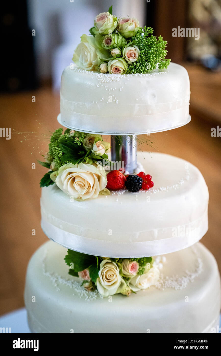 wedding cake decorated with berries and flowers Stock Photo