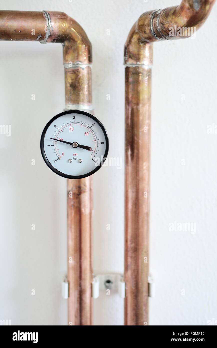 Closeup of pressure gauge connected to copper heating pipe Stock Photo