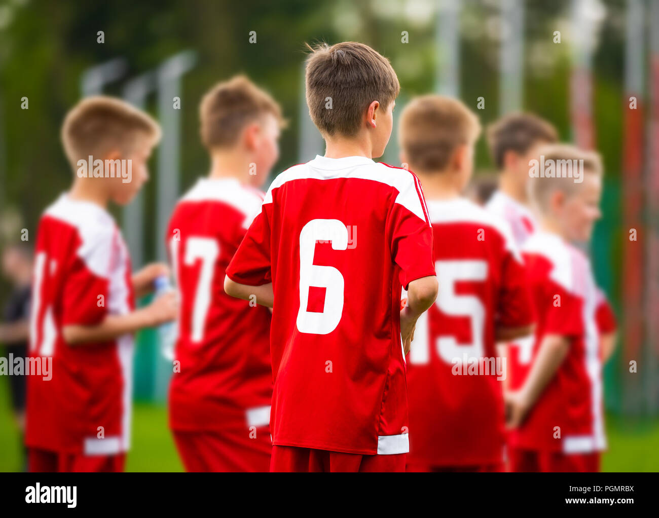 Boys football team together. Young football soccer players in jersey red sportswear Stock Photo