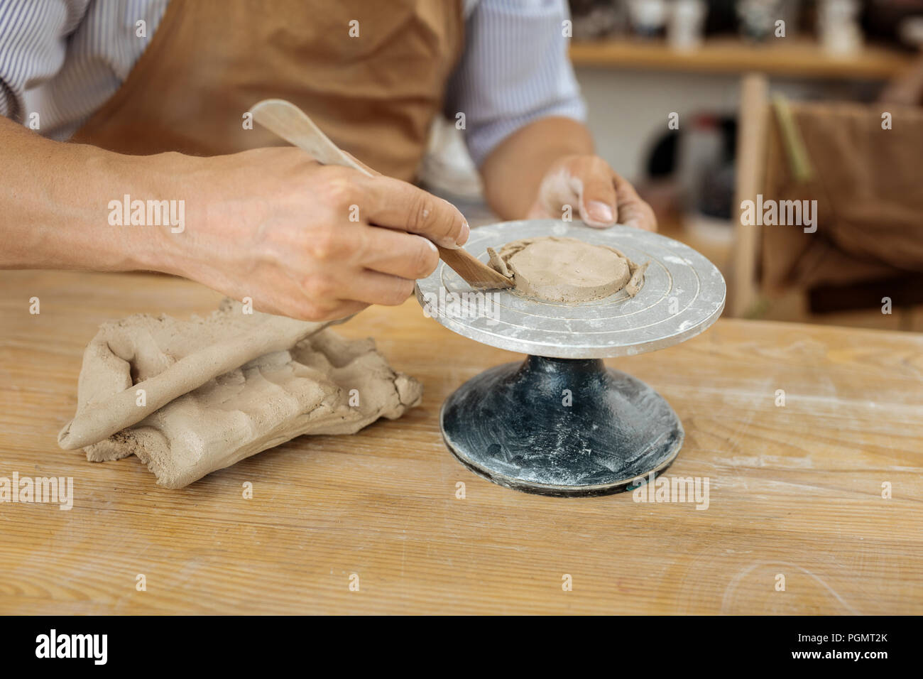Handicraftsman wearing apron forming future clay items Stock Photo