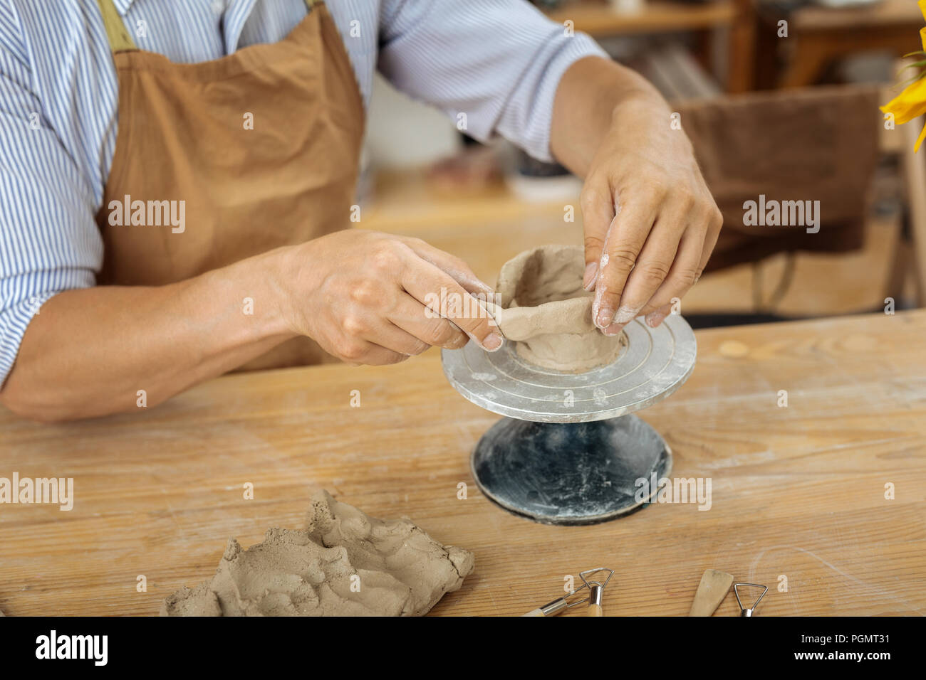 Handicraftsman wearing apron working with pottery wheel Stock Photo Alamy