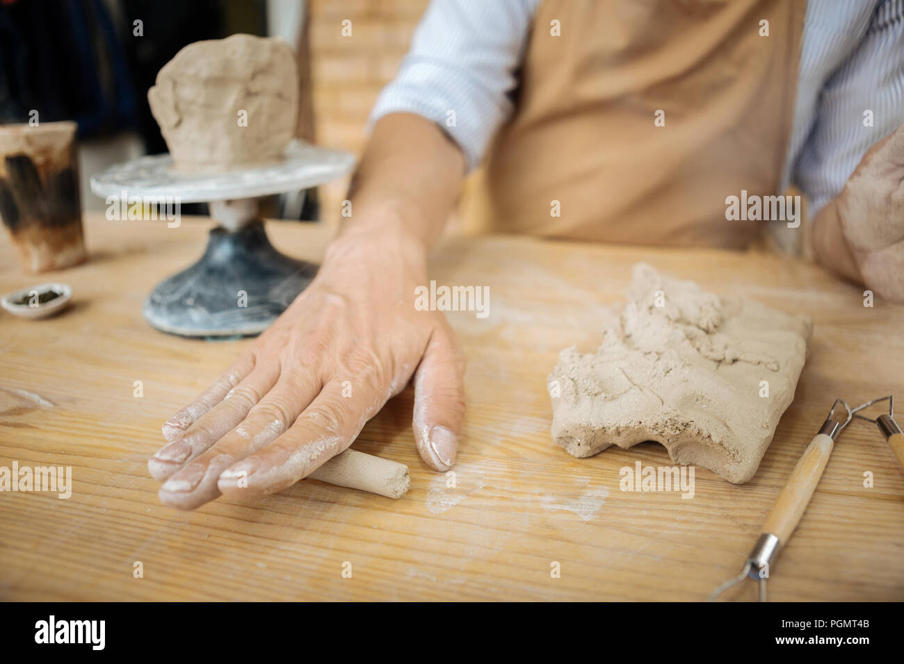 Potter using professional equipment while forming clay vase Stock Photo