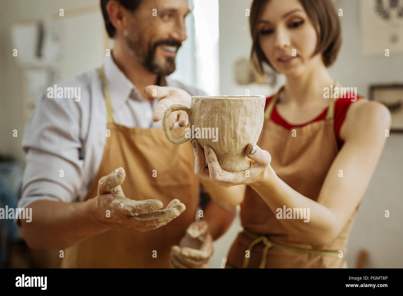 Young couple leaving pottery master class with their own cup Stock Photo