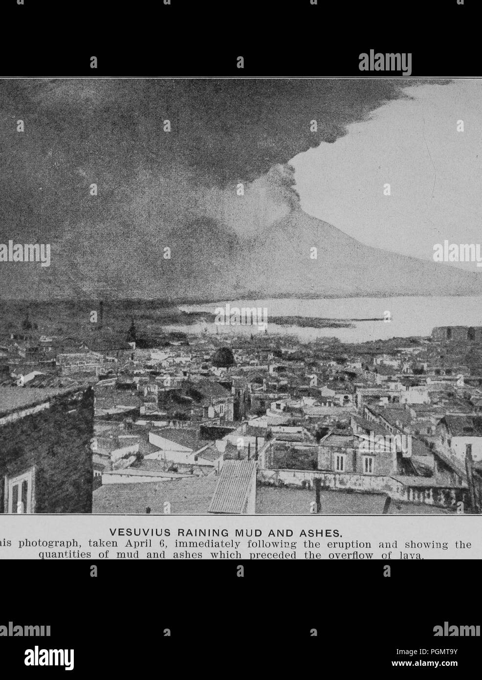 Black and white photograph showing a cloud of mud and ash emanating from Mount Vesuvius and hanging over an Italian seaside town following a volcanic eruption on April 5, 1906, 1906. Courtesy Internet Archive. () Stock Photo