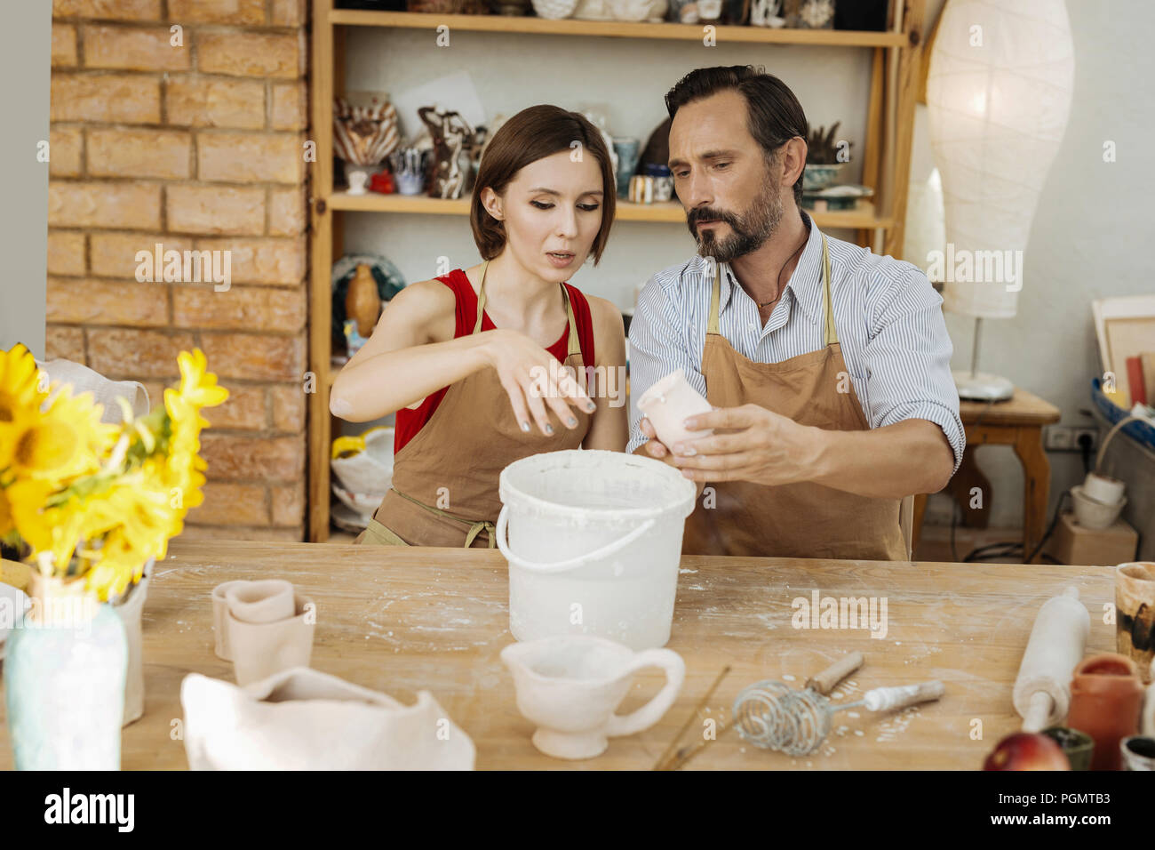 Dark-haired woman attending master class in ceramics Stock Photo