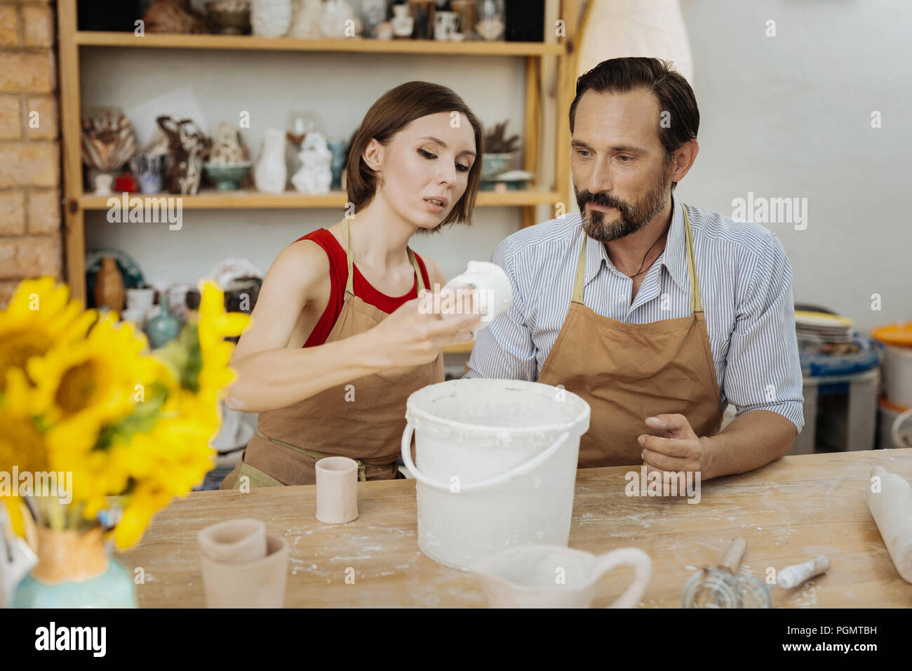 Dark-haired female potter showing her students some secrets Stock Photo