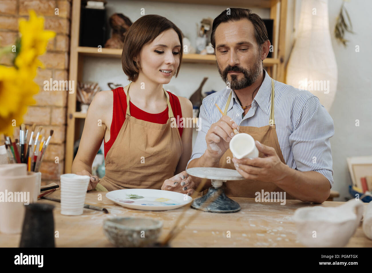 Handsome bearded professional handicraftsman giving master class Stock Photo