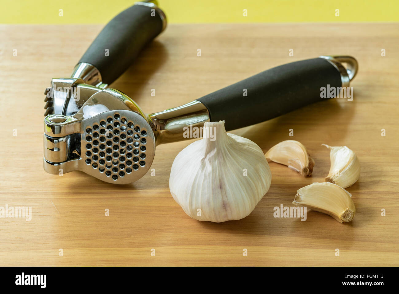 https://c8.alamy.com/comp/PGMTT3/garlic-crusher-or-press-with-a-bulb-and-cloves-PGMTT3.jpg