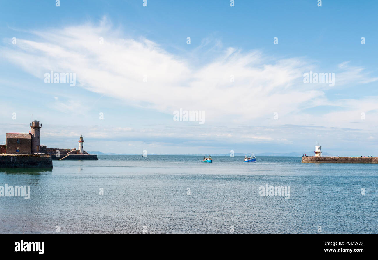An image of fishing boats returning to shore taken on a summers day at Whitehaven, Cumbria, England, UK Stock Photo