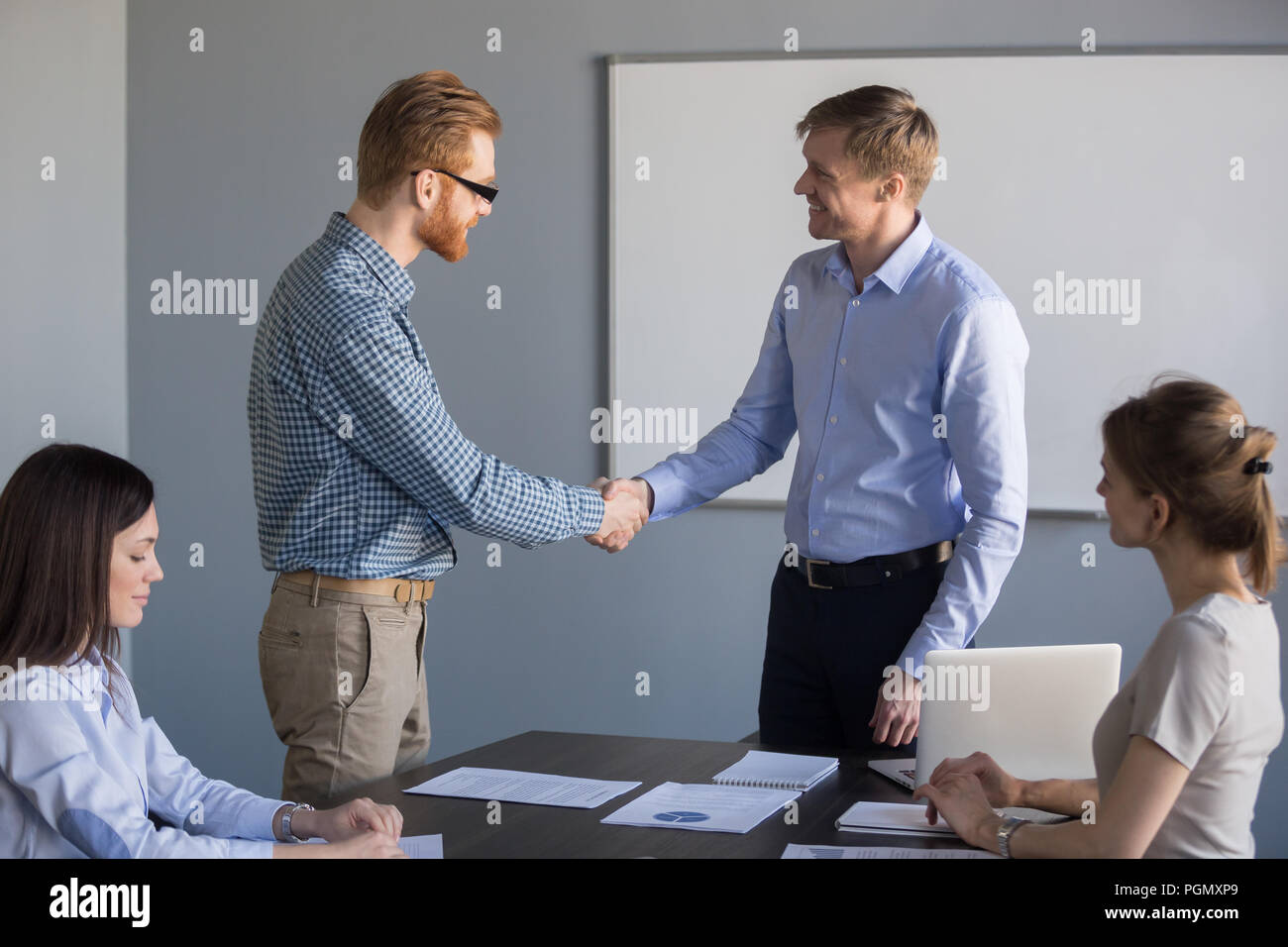 Smiling businessman handshake male worker congratulating with su Stock Photo