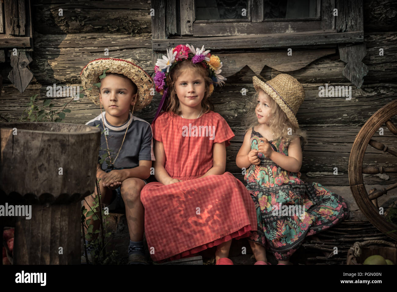 Countryside rustic lifestyle children sitting together old countryside house  symbolizing kids friendship and happy carefree rustic childhood Stock Photo