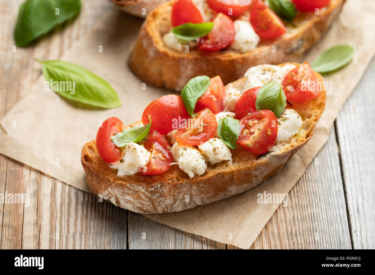Bruschetta with tomatoes, mozzarella cheese and basil on a old rustic