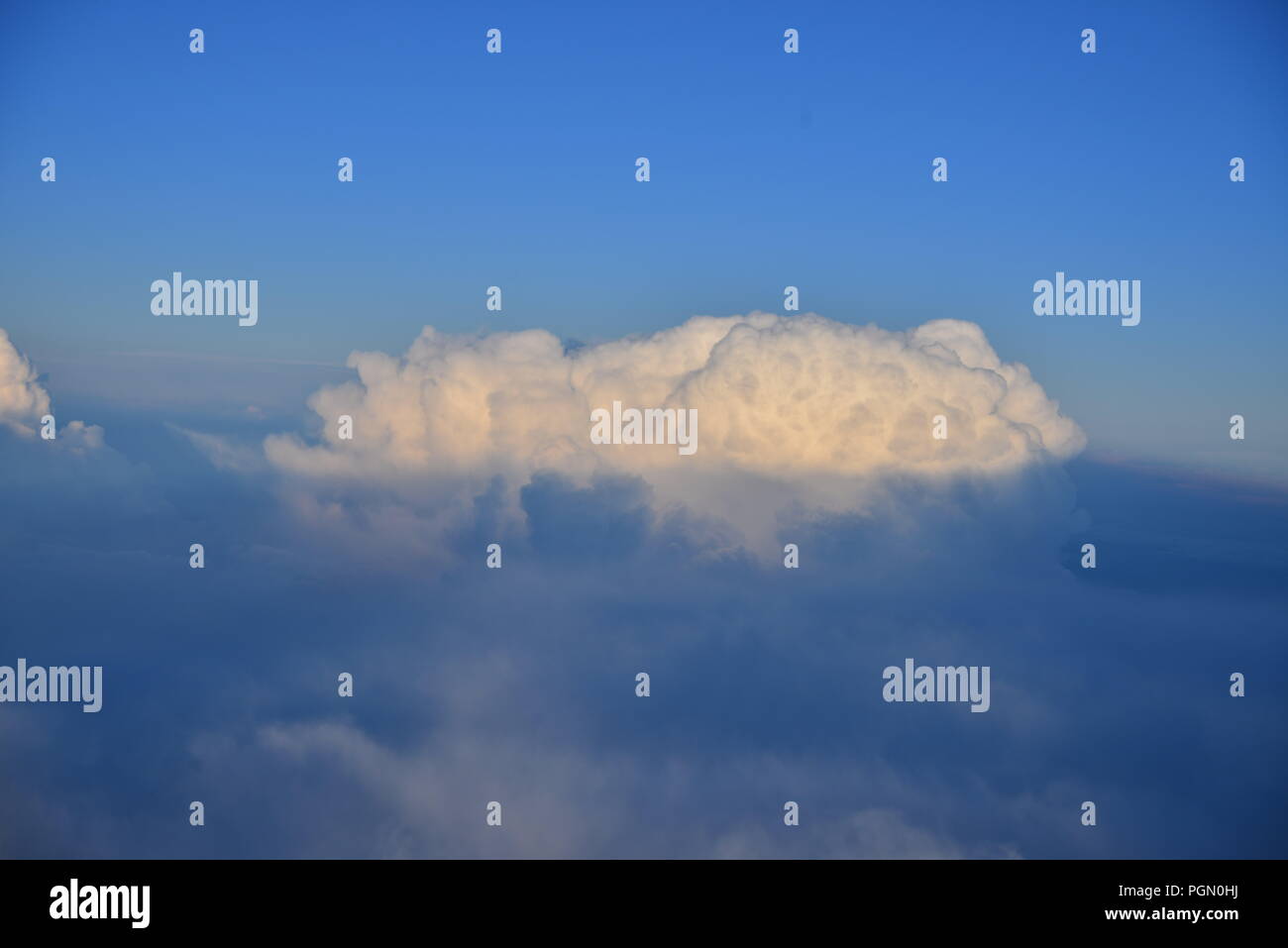 Cumulus cloud floating in a sea of blue Stock Photo