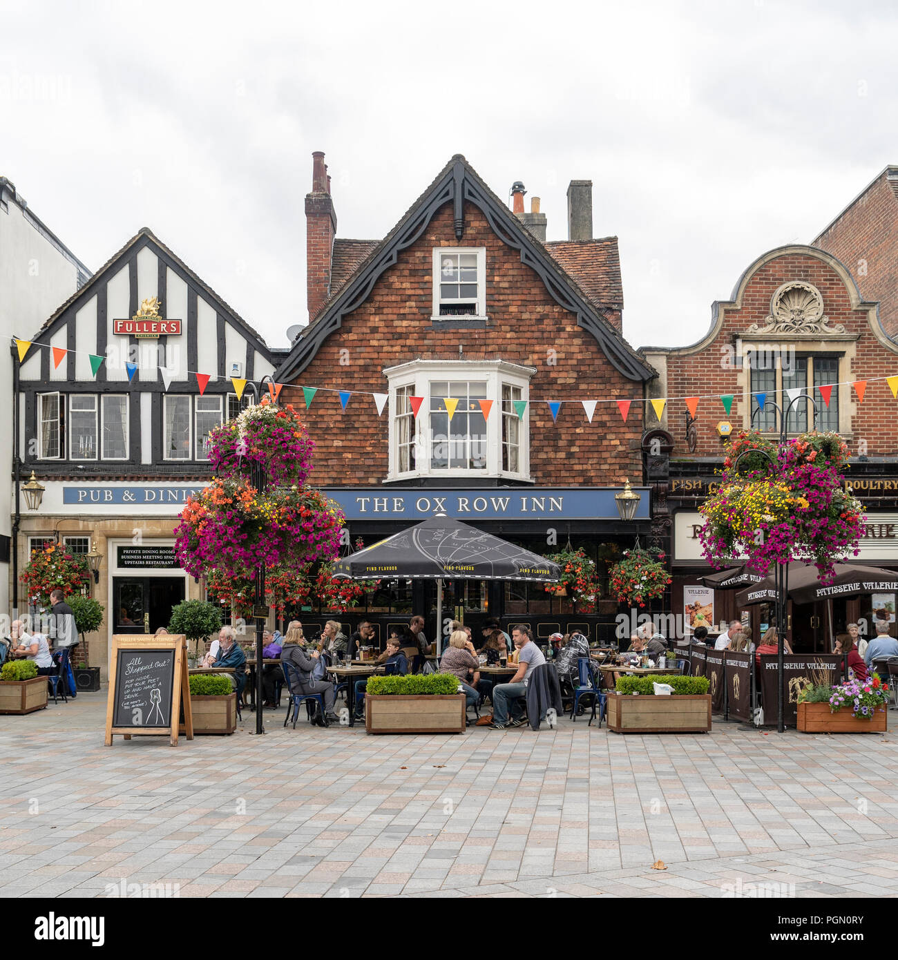 People sitting at tables outside of the Ox Row Inn Salisbury Market square UK Stock Photo