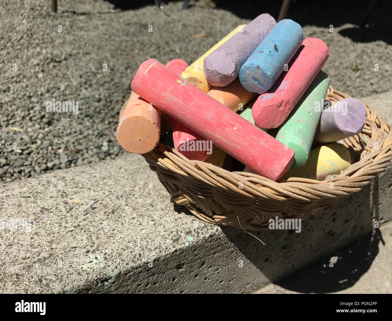 colorful chalk sticks in the basket to draw art on concrete floor
