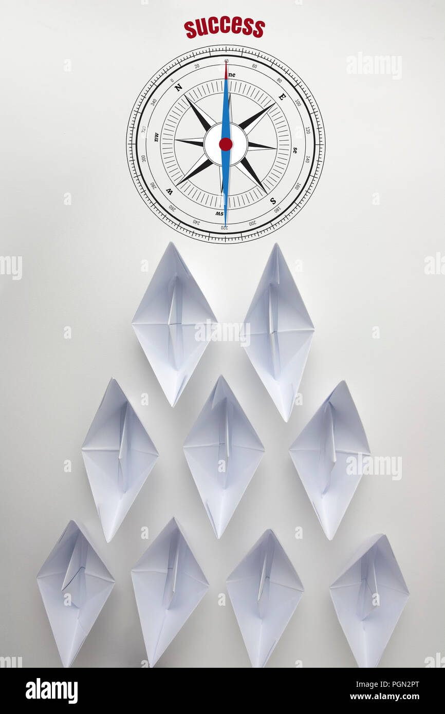 Abstract compass with needle pointing the word success in front of ...