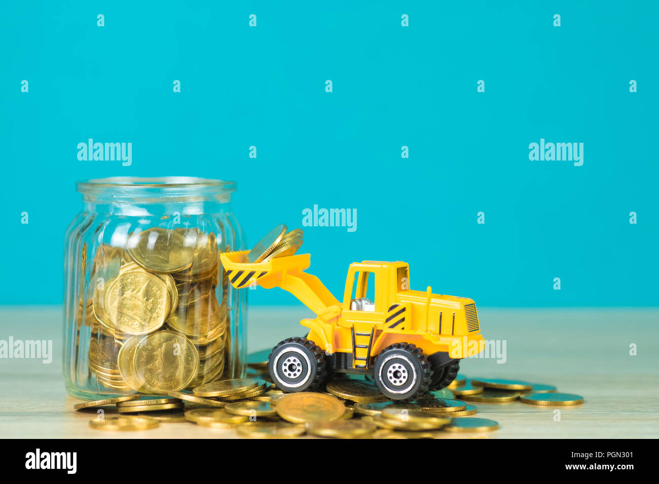 Loading Coin Mini bulldozer truck loading stack coin with pile of gold coin to glass ...