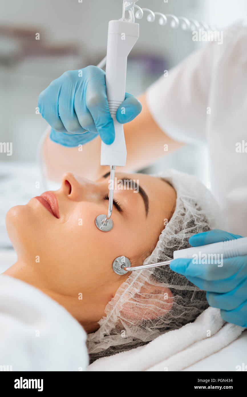 Nice young woman having the microcurrent therapy session Stock Photo