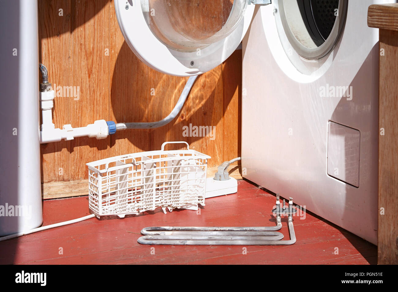 damaged washing machine heating element on the foor Stock Photo Alamy